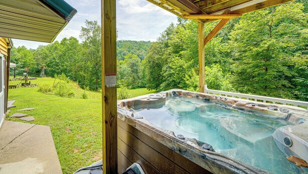 A hot tub with a wooden deck and a view of a forested area. - Hot Tub + Pet Friendly: Quiet French Creek Getaway (French Creek)