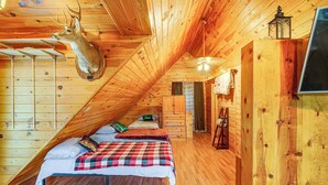 A cozy attic bedroom with wooden walls, a mounted deer head, and a bed with a plaid blanket. - Hot Tub + Pet Friendly: Quiet French Creek Getaway (French Creek)