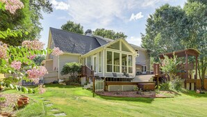 A house with a covered patio, a fenced backyard, and a well-maintained lawn.