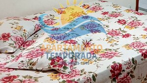 Una cama con colcha estampada con flores y un diseño de sol.