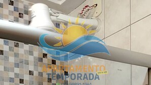 Un mur recouvert de carreaux avec un motif décoratif et un logo représentant un soleil.