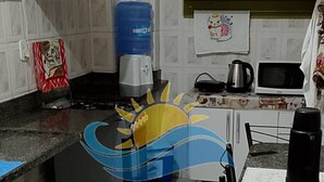 Una cocina con encimera de granito, cafetera, hervidor y microondas.