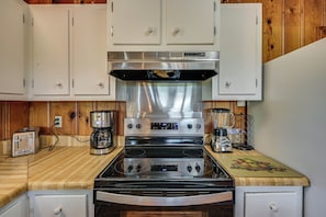 A kitchen with a stainless steel stove, white cabinets, wooden countertop, and a coffee maker. - 2 Mi to Oak Grove Racing & Gaming: Home on 1 Acre (Oak Grove)