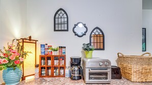 Una encimera de cocina con cafetera, tostadora y una cesta.