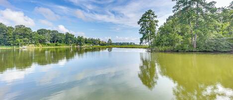 Un lac paisible dont les eaux reflètent clairement le ciel et les arbres environnants.