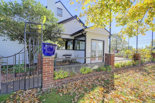 A house with a covered porch, a brick wall, and a garden with various plants and leaves. - Gastropub On-site: Loudoun Wine Country Apartment (Hamilton)