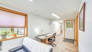 Ett rum med ett skrivbord, en stol och en vadderad bänk.