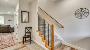 A staircase with wooden steps and black railings, a wall-mounted decorative item, and a door with a 'Shut the Door' sign. - Explore Alaskas Playground: Modern Wasilla Escape (Wasilla)