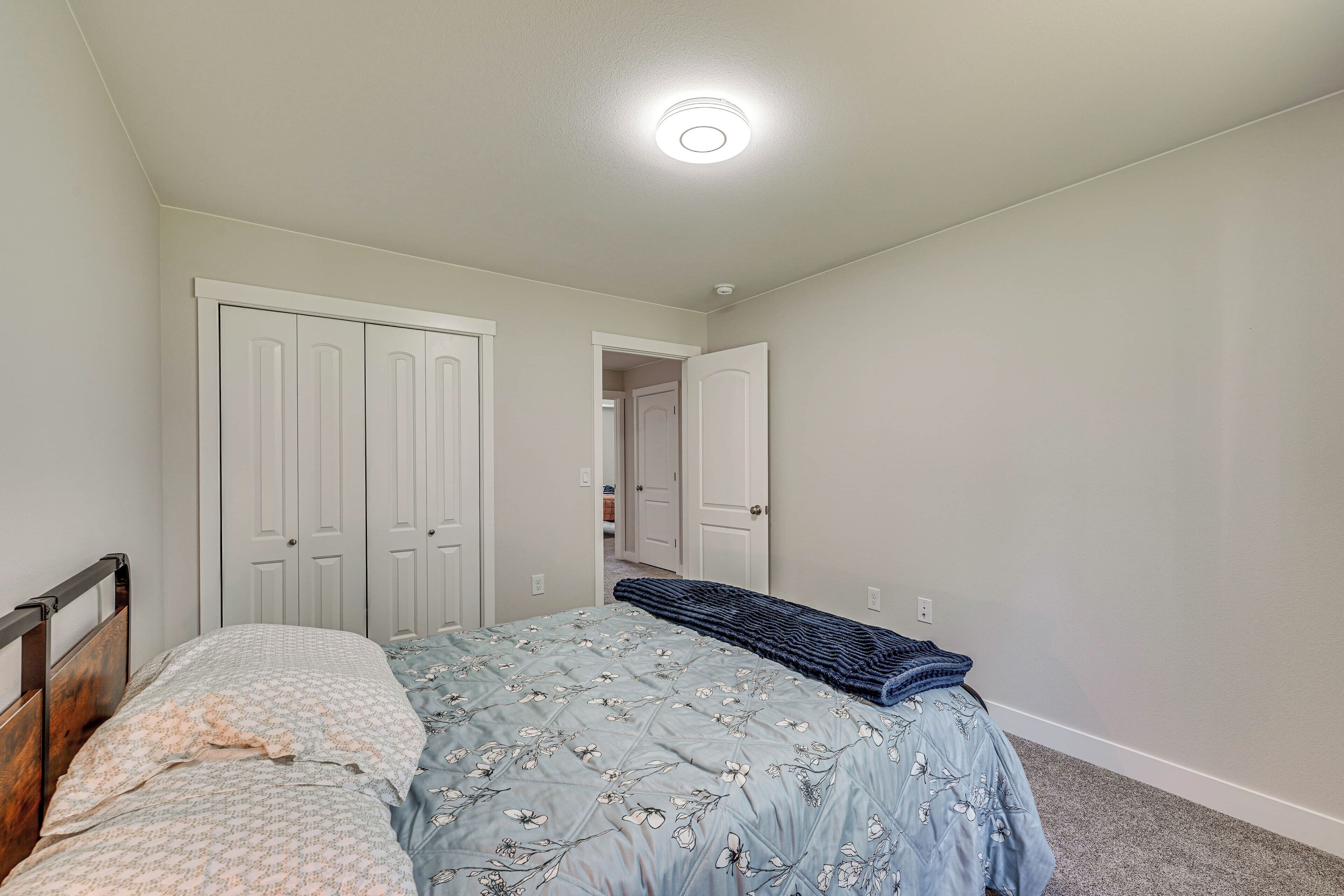 A bedroom with a bed, a wardrobe, and a door leading to another room.