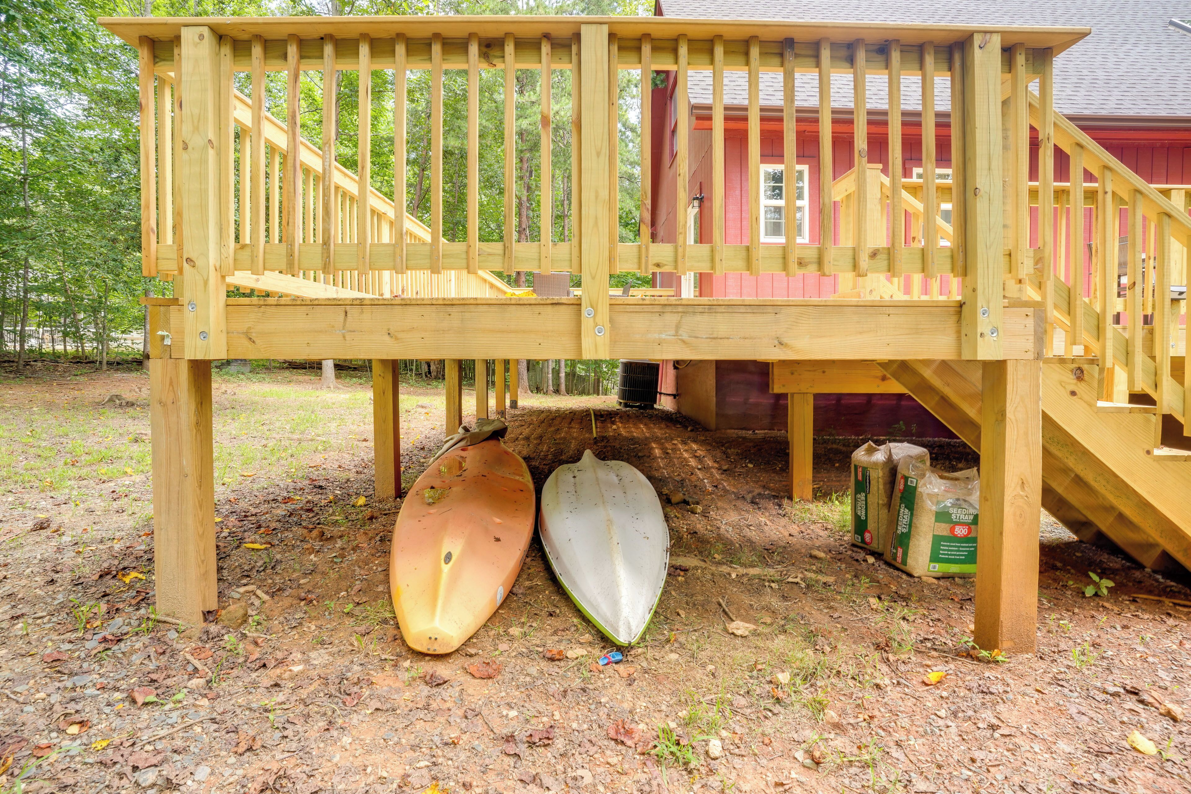 A wooden deck with two kayaks underneath.