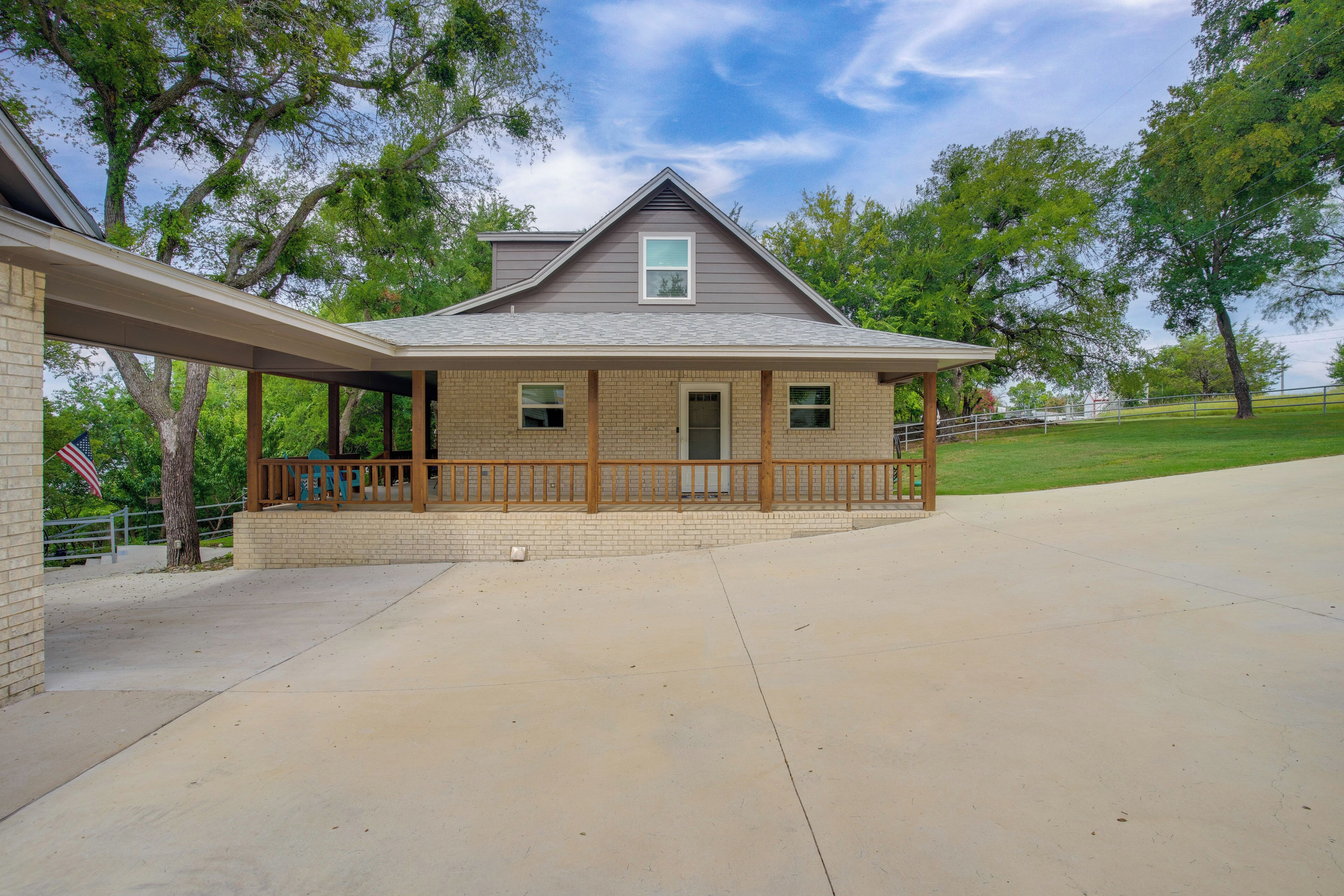 A two-story house with a covered porch, brick exterior, and a small front yard.