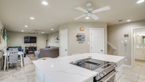 A modern kitchen with a built-in stove, oven, and microwave. There is a dining area with a table and chairs, and a living room with a couch and TV. - Waterfront Lake Bridgeport Home w/ Private Dock (Bridgeport)