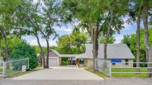 A gated driveway leading to a building with a garage and a covered porch. - Waterfront Lake Bridgeport Home w/ Private Dock (Bridgeport)