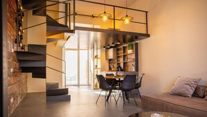 Un intérieur moderne comprenant un escalier, un coin repas et un espace détente.