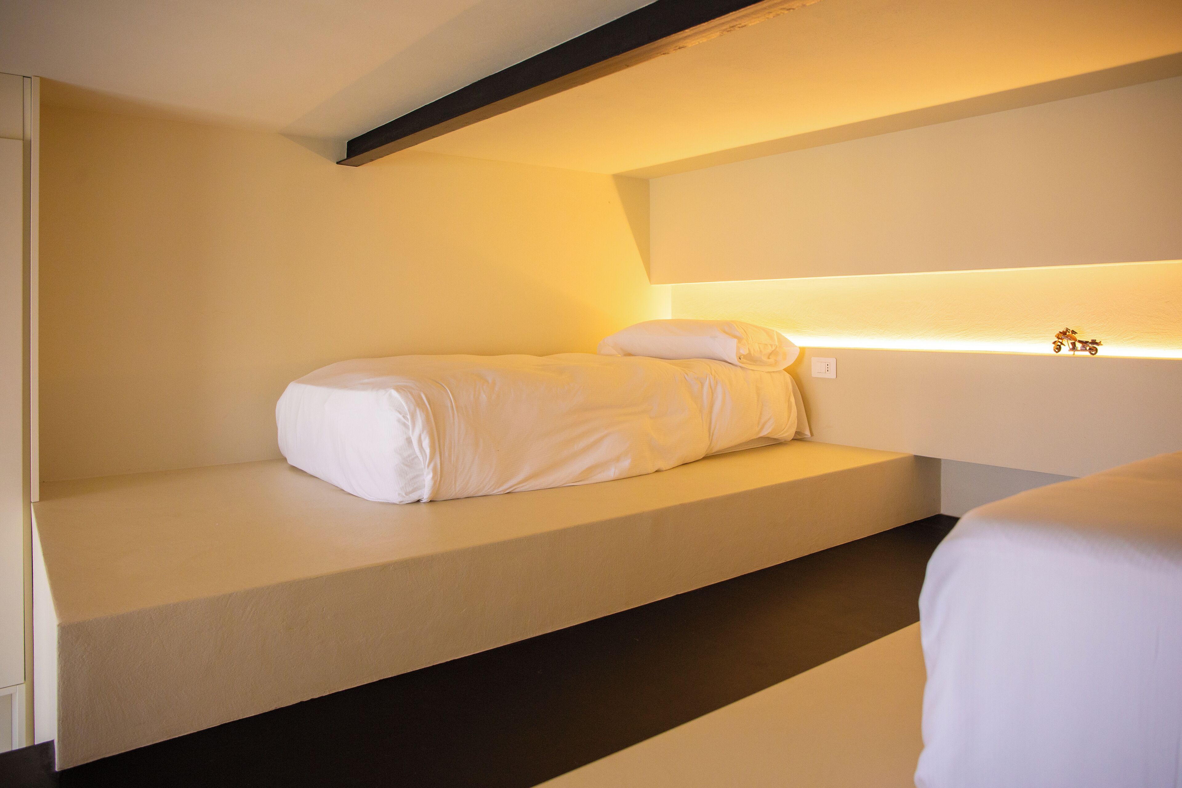 A single bed with a headboard and a bedside table in a hotel room.