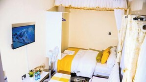 Habitación de hotel con cama, escritorio con computadora, televisión y un cartel de LUXY LIFE APARTMENTS.