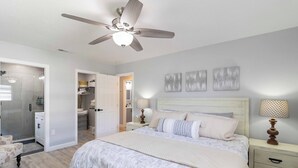 A bedroom with a bed, bedside tables, a ceiling fan, and a walk-in closet. - FOX's Hidden Oasis 2 BR Pool Home 3 miles to AMI beaches (Bradenton)