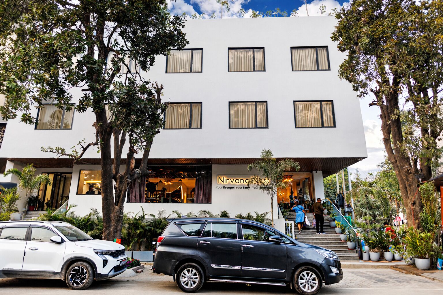 A modern building with a sign reading 'Nirvana West' and a staircase leading to the entrance.