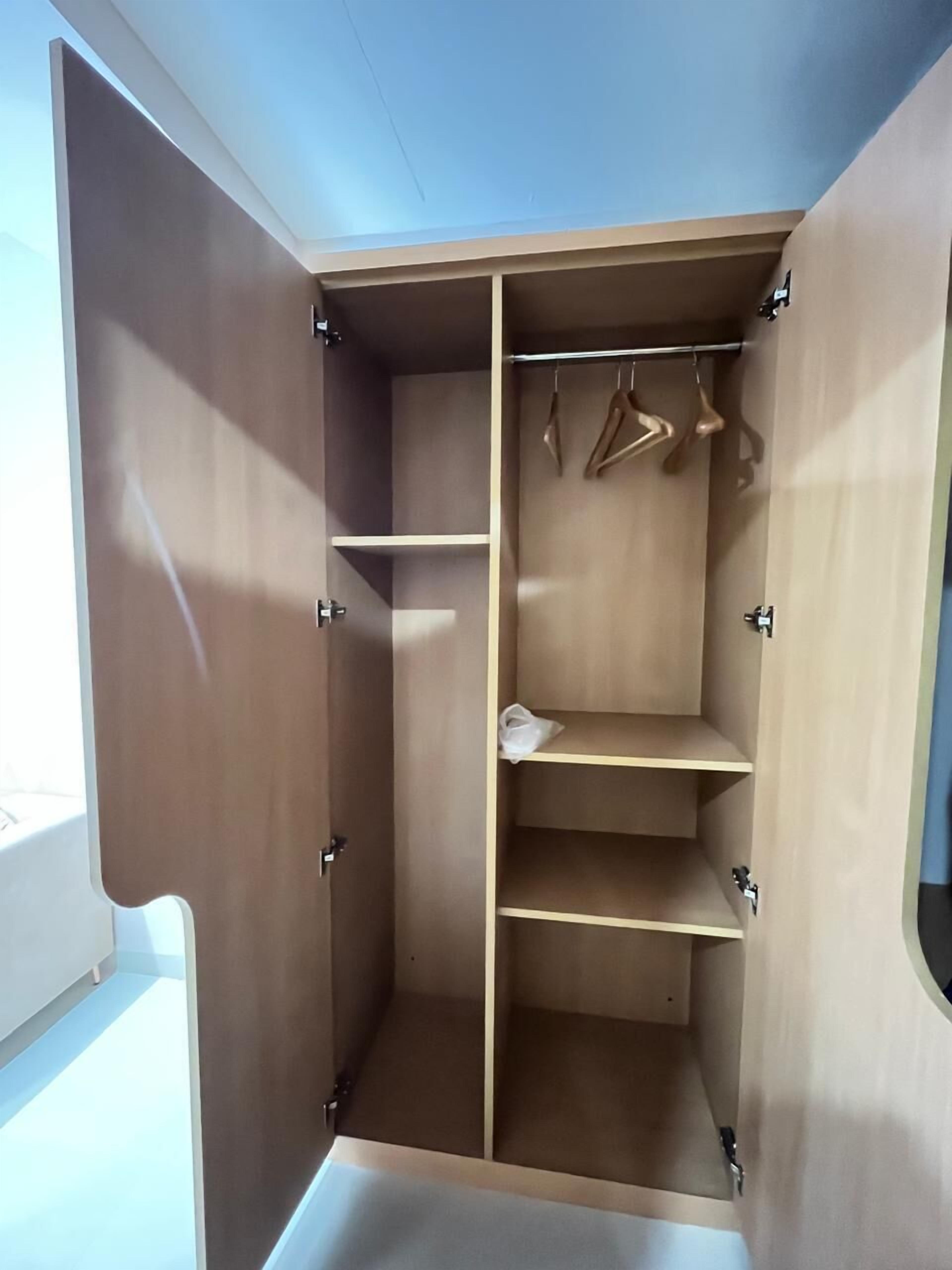 A walk-in closet with multiple shelves and hanging space.