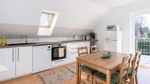 A compact kitchen with a skylight, a coffee machine, a toaster, and a refrigerator. - 90 sqm Cozy home cinema with balcony & projector (Kassel)