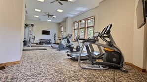 A gym with treadmills, stationary bikes, and a weightlifting area.