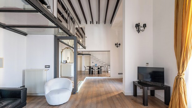 A modern living room with a staircase, a TV, and a dining area. - Appartamento Sammartino by Wonderful Italy (Palermo)