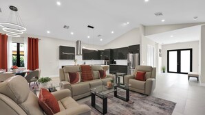 Una sala de estar moderna con un conjunto de sofá, una mesa de centro de vidrio y una zona de comedor con mesa y sillas.
