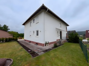 A white two-story house with a sloped roof, a small front porch, and a well-maintained lawn. - Apartment 'Daniela Fellen - Magda' with Mountain View, Shared Terrace and Wi-Fi (Fellen)