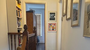 A staircase with a wooden handrail leading to a landing. - Traditional Victorian house (Hastings)