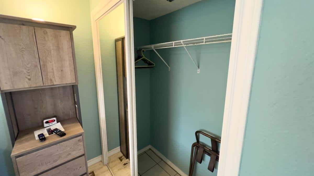 Ein Badezimmer mit Holzschrank, Handtuchhalter und Duschbereich.