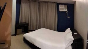 Ein Hotelzimmer mit Bett, Schreibtisch und Stuhl.