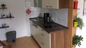 Una cocina moderna con encimera de madera, pileta de acero inoxidable y muebles de cocina.