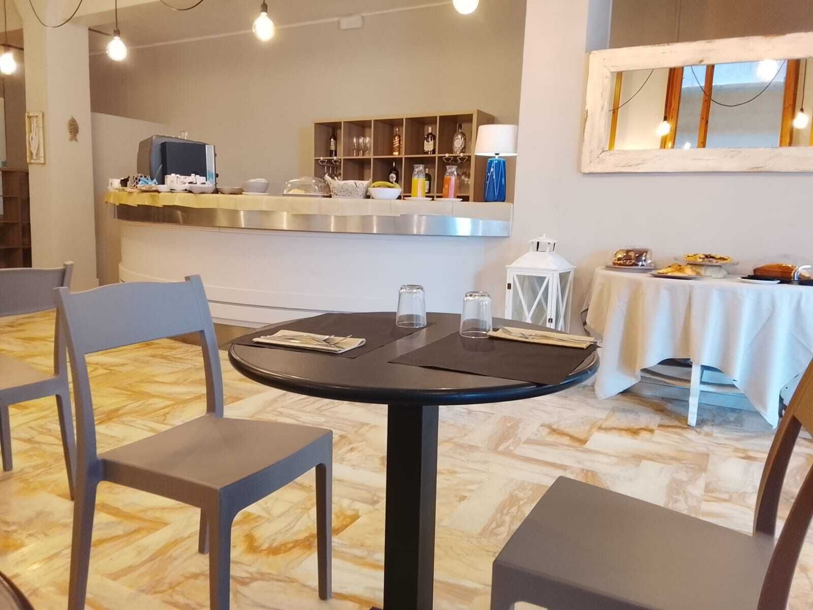 Een eethoek met een ronde tafel, twee stoelen, een aanrecht met diverse spullen en een decoratieve lantaarn.