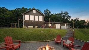Un chalet rustique doté d’un foyer extérieur et de sièges pour profiter de l’extérieur.