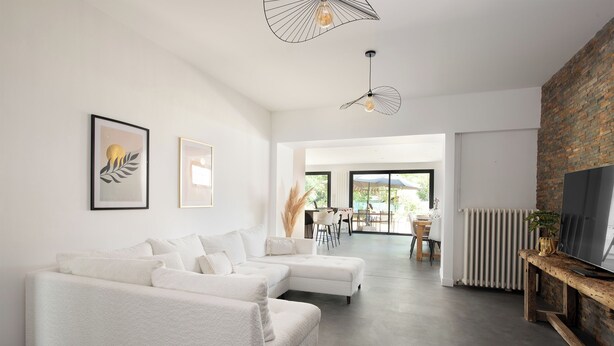 A modern living room with a sectional sofa, a fireplace, and a television on a wooden stand.
