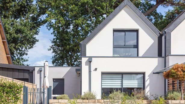 A modern two-story house with a stone wall, a wooden fence, and a variety of plants. - Holiday Home 'Korñog Near the Beach' with Private Terrace, Wi-Fi and Air Conditioning (Fouesnant)