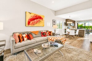 A modern living room with a sofa, coffee table, and artwork.