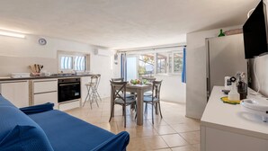 A compact kitchen with a dining area, a built-in oven, and a refrigerator. - Holiday Home 'Casa Ros' with Sea View, Wi-Fi and Air Conditioning (Palermo)
