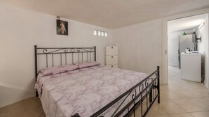 A bedroom with a bed, a dresser, a small window, and a bathroom visible through an open door. - Holiday Home 'Casa Ros' with Sea View, Wi-Fi and Air Conditioning (Palermo)