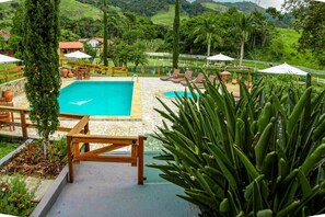 Una piscina al aire libre, sombrillas, tumbonas