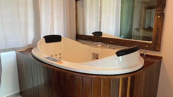 A modern bathroom with a freestanding bathtub, wooden paneling, and a large mirror.