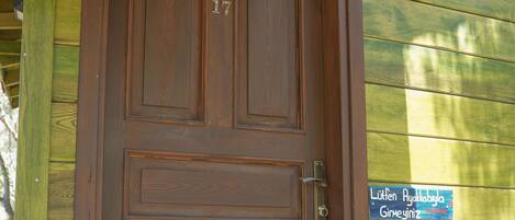 Una puerta de madera con el número “17” y un letrero encima.