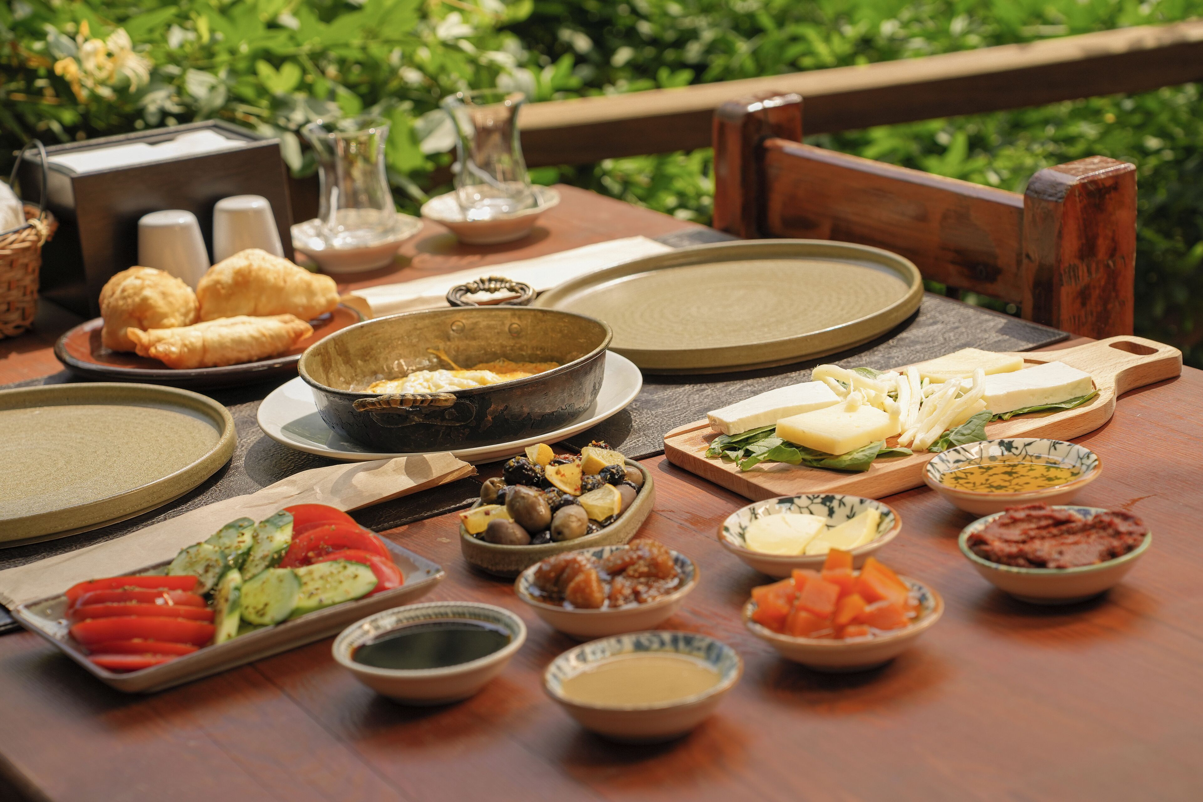 Ein Tisch ist gedeckt mit verschiedenen Speisen, darunter Brot, Käse und Gemüse, was auf eine Mahlzeit hindeutet.