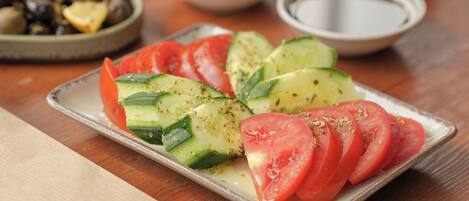 A plate of sliced tomatoes and cucumbers on a tray.