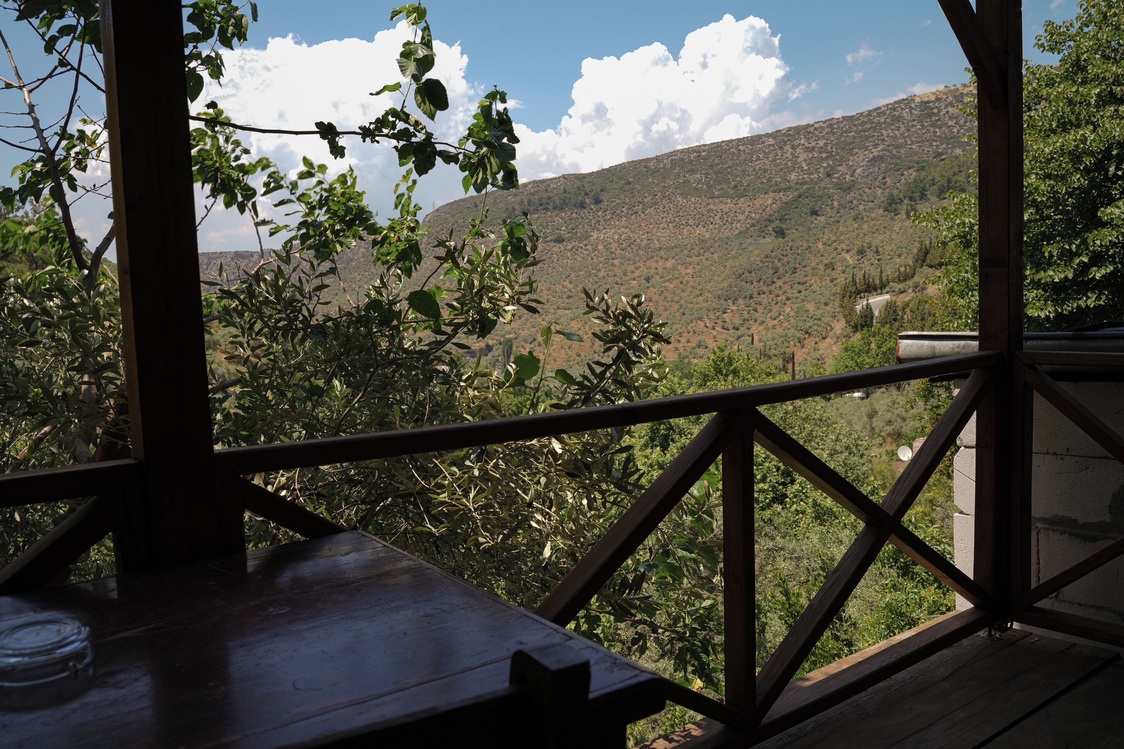 Una terraza de madera con vistas a un paisaje montañoso.