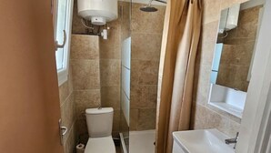 A bathroom with a toilet, shower, and sink. - Cosy studio close to amenities + sea 5 minutes away (Fos-sur-Mer)