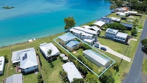 Vista aérea de una zona residencial costera con casas, una carretera y una extensa masa de agua.
