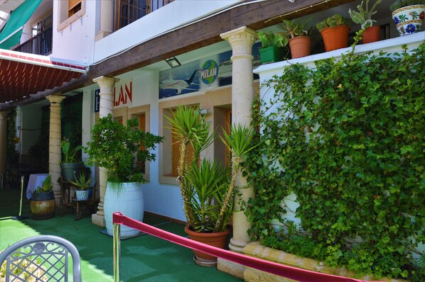 Un edificio con un letrero que dice "LAN" y un balcón con plantas en macetas.