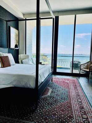 Un dormitorio moderno con una cama grande, vistas al mar y un balcón.