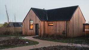 Ein modernes Holzhaus mit Satteldach und einer sichtbaren Tür.